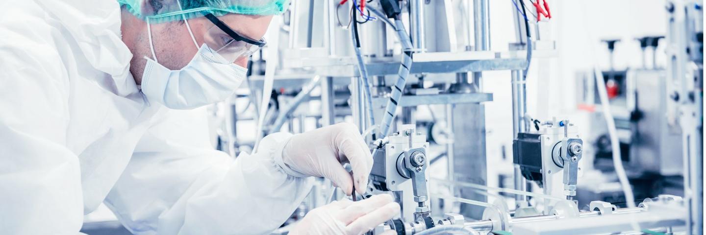 A person in PPE adjusts equipment