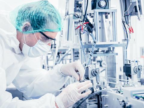 A person in PPE adjusts equipment